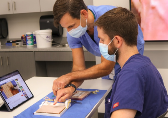 Kyle Schneider, a medical student at the TCU and UNTHSC School of Medicine gets instructions on knot tying from John Birbari, M.D., an assistant professor at the medical school.