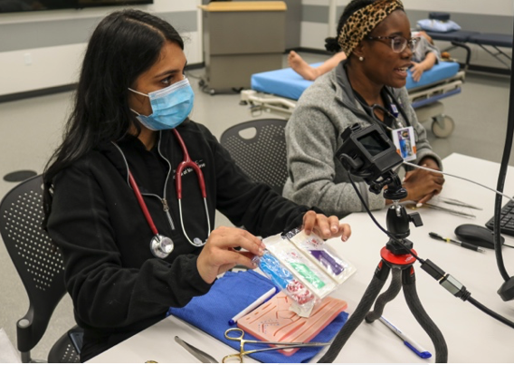 women about how to use a suturing kit during a Mini Medical School program for the Latina STEM Fellowship on April 24, 2021.