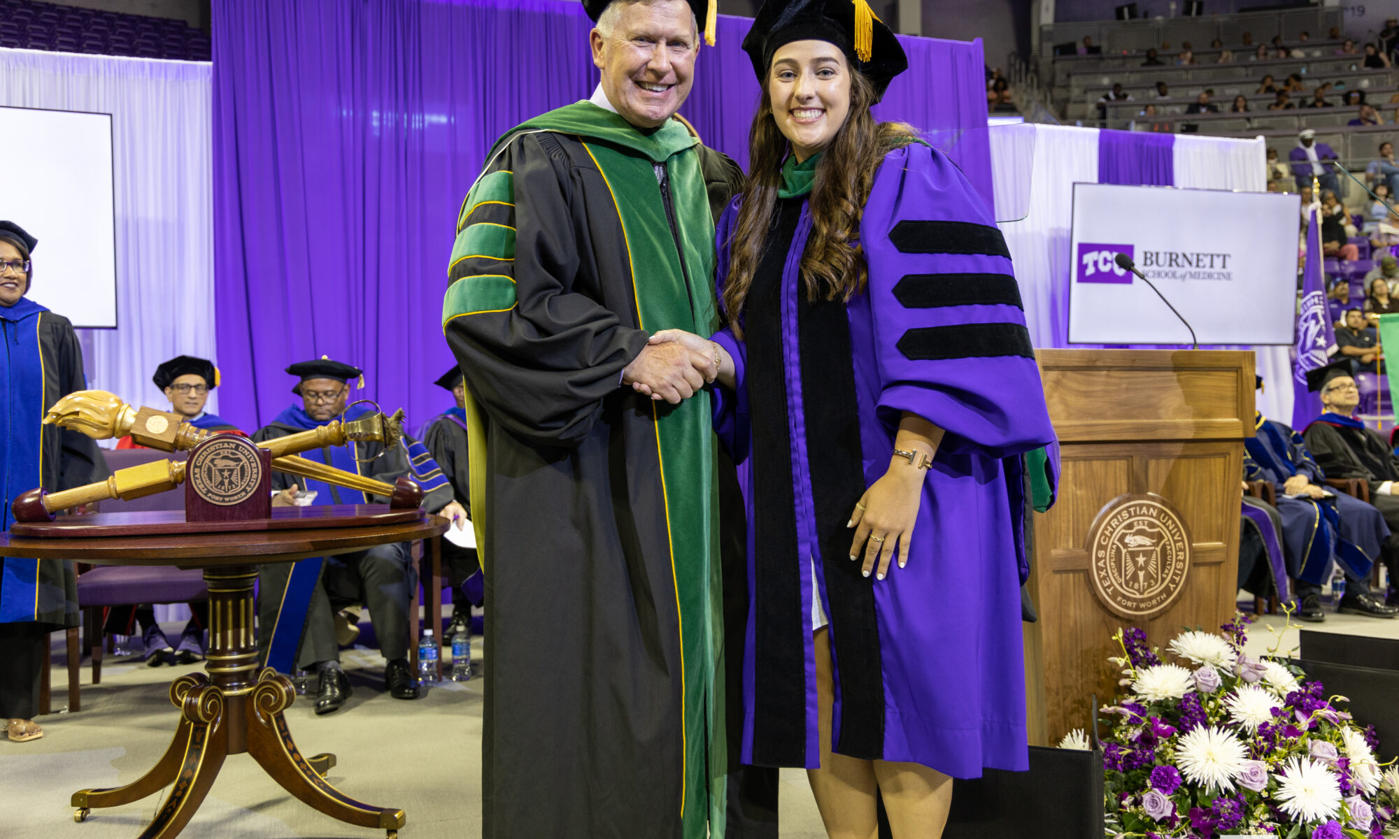 Lindsay Zumwalt, M.D. '25, (right) shakes hands with Founding Dean Stuart D. Flynn, M.D., at the Anne Burnett Marion School of Medicine at Texas Christian University Commencement on May 9, 2025.