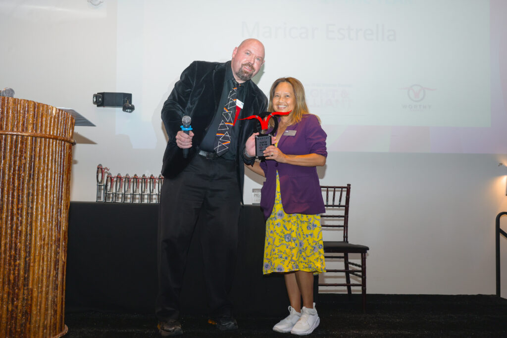 Maricar Estrella, MBA, Director of Digital Development and Content Strategy at the Burnett School of Medicine at TCU, receives the Volunteer of the Year Award at the GFW PRSA Worthy Awards on November 7, 2025 in Fort Worth.